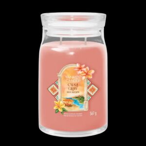 A tall cylindrical glass jar full of some pale pink wax with a label that has Yankee Candle written in bright white writing, Capri Glow written in bright white writing, and a picture of some bright orange beach unbrellas on a golden sandy beach on it, on a white background.