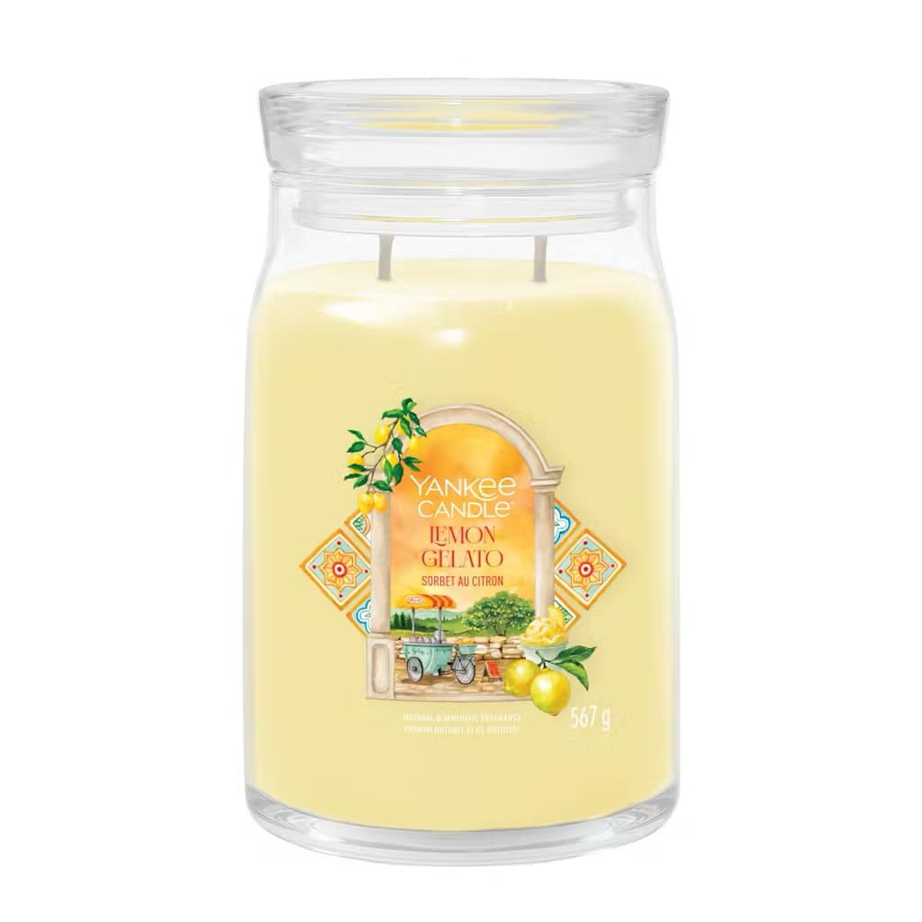 What I Thought of the Yankee Candle Advent House 2014 A tall cylindrical glass jar full of some pale yellow wax with a label that has Yankee Candle written in bright white writing, Lemon Gelato written in bright white writing, and a picture of some bright yellow lemons next to a tall gelato stand on it, on a white background.