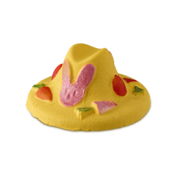 A large bright yellow easter bonnet shaped bubble bar that has a bright pink bunny rabbit, some bright red dots, and some orange Carrots engraved on it, on a white background.
