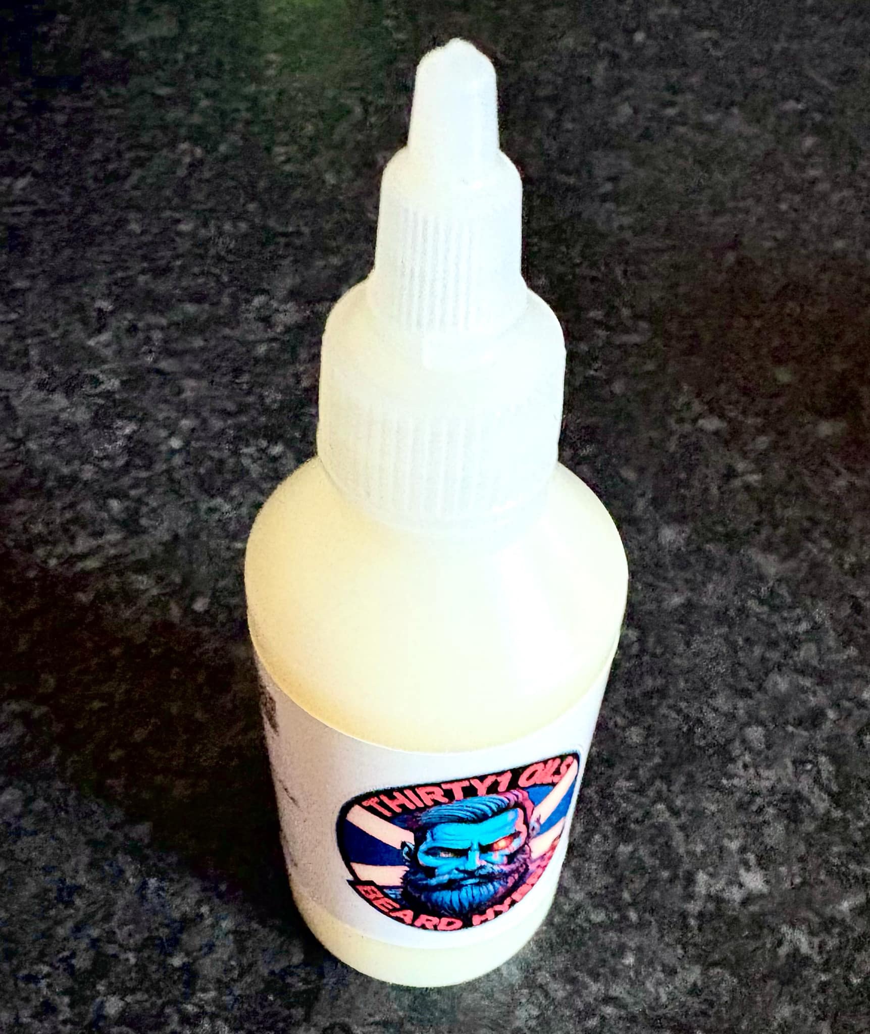 Hopefully I Don’t Look Like I Have Just Been Dug Up From A Grave | Thirty 1 Oil Sherbet Zombie Beard Hybrid A short cylindrical clear plastic bottle full of some creamy white liquid with a bright white plastic lid and a bright white label that has Thirty 1 Oils Sherbet Zombie Beard Hybrid written in bold black writing and a picture of a man’s face with a blue beard on it, on a white background.