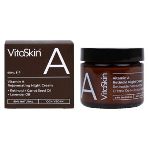 A short cylindrical dark brown glass jar with a metallic black lid and a dark brown label that has Vitaskin Rejuvenating Night Cream written in bold bright white writing and a picture of a letter A on it next to a short square dark brown cardboard box that has Vitaskin Rejuvenating Vitamin A Night Cream written in bright white writing on it, on a white background.