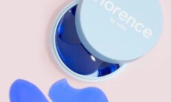 Several translucent bright blue wave shaped pieces of Carrageenan inside a short circular bright blue plastic case that has Florence by Mills written in bright white writing on it, on a white background.