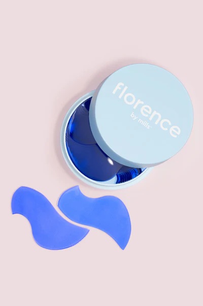 Getting Splashed By The Surf Always Leaves Me With Hydrated Under Eyes | Florence By Mils Surfing Under The Eyes Hydrating Treatment Gel Pads Several translucent bright blue wave shaped pieces of Carrageenan inside a short circular bright blue plastic case that has Florence by Mills written in bright white writing on it, on a white background.
