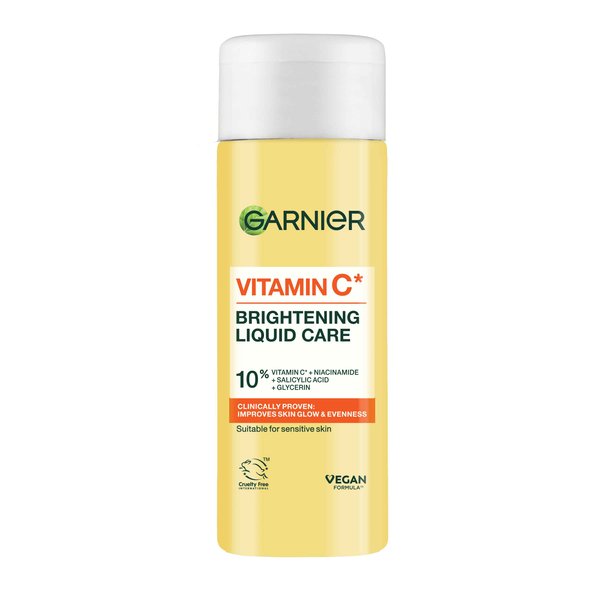 A tall cylindrical bright yellow plastic bottle with a bright white plastic lid and a bright white label that has Garnier Vitamin C* Brightening Liquid Care written in bold black writing on it, on a white background.