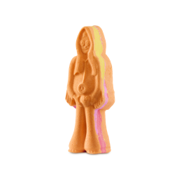 A medium bright orange man shaped bath bomb that has some long bright yellow hair, a gradient bright orange, pink and yellow fringed jacket, a pair of gradient orange pink and yellow flared trousers, a black peace symbol necklace, and a pair of black rimmed glasses engraved on it, on a white background.