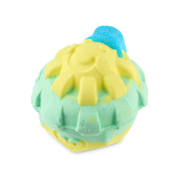 A medium bright yellow spherical sun shaped bath bomb with a bright blue sun hat that has a smiling face engraved on it sat on a gradient bright green and yellow base, on a white background.