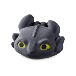 But I Would Bring You Rings Of Gold | Lush x How To Train Your Dragon Range A large black dragon’s head shaped bath bomb that has some large bright green eyes, some black slicked-back ears, and a wide toothless mouth engraved on it, on a white background.