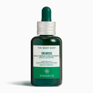 A short cylindrical bright green glass bottle with a dark green Rubber Pipette Lid that has The Body Shop Edelweiss Daily Serum Concentrate written in dark green writing on it, on a white background.