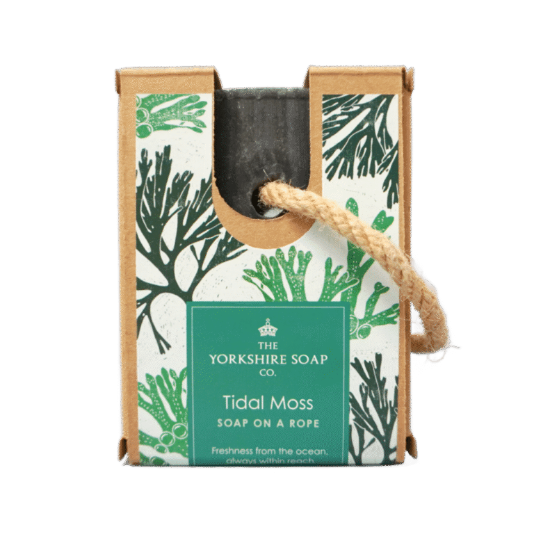 Yorkshire Smelt So Fresh And Clean In The 70's | The Yorkshire Soap Company Soap On A Rope Bar Range A medium rectangular dark blue block of soap inside a medium rectangular cardboard box with a dark green label that has The Yorkshire Soap Company Tidal Moss Soap On A Rope Bar written in bold bright white writing, some pictures of some bright green pieces of Seaweed, and a piece of light brown rope tied around it, on a white background.