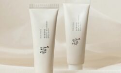 A tall conical creamy white plastic tube with a creamy white plastic lid that has Beauty of Joseon Relief Sun Rice + Probiotic SPF50+ PA++++ written in bold black writing on it next to a tall conical creamy white plastic tube with a creamy white plastic lid that has Beauty of Joseon Relief Sun Rice + Probiotic SPF50+ PA++++ written in bold black writing on it, on a white background.