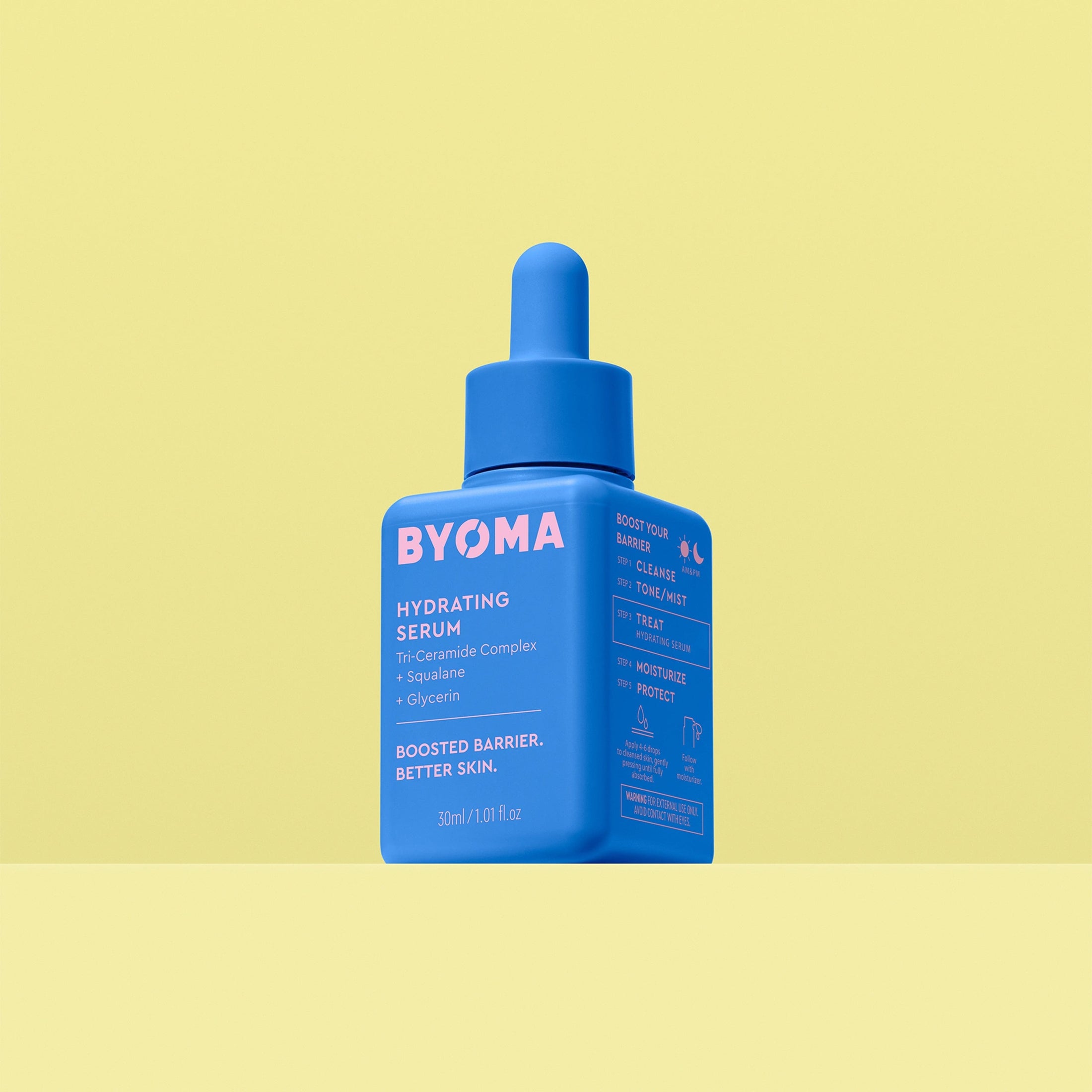 By Heck, That’s Some Hydrated Skin! | Byoma Hydrating Serum A short square bright blue plastic bottle with a bright blue rubber pipette lid that has Byoma written in bright pink writing and Hydrating Serum written in bright white writing on it, on a pastel yellow background.