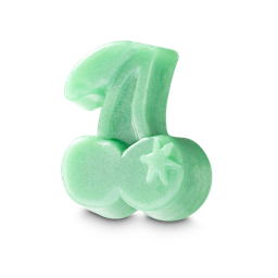 A small pastel green cherry shaped block of soap that has a bright gold six-pointed star engraved on one side of it and some silver Lustre all over it, on a white background.