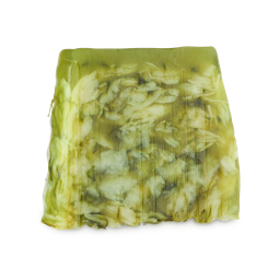 A medium gradient translucent green and white trapezium shape block of soap that has some flower petals and leaves engraved on it, on a white background.