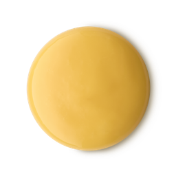 A medium circular puddle of some creamy golden yellow shower gel, on a white background.