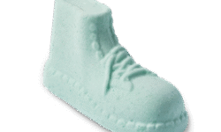 A small pale Mint green hightop boot shaped bath bomb that has some laces, some Eyelets, and a textured sole engraved on it, on a white background.