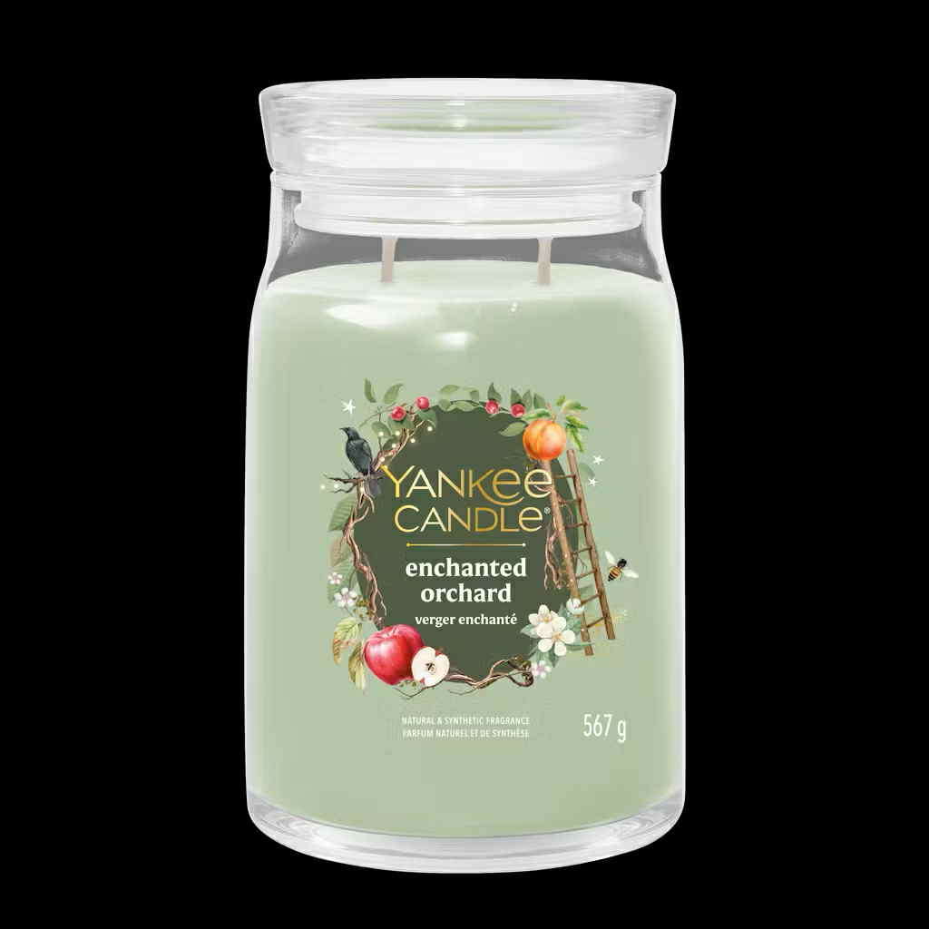 What I Thought of the Yankee Candle Advent House 2014 A tall cylindrical glass jar full of some pale green wax with a label that has Yankee Candle written in bright white writing, Enchanted Orchard written in bright white writing, and a picture of some dark green apples, a large orange, a ladder, a small black bird, some white blossom flowers, and some dark brown branches on it, on a black background.