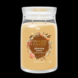 A tall cylindrical glass jar full of some pale brown wax with a label that has Yankee Candle written in bright white writing, glistening Leaves written in bright white writing, and a picture of some golden orange leaves, some oranges, a slice of Fig, and a gold ribbon on it, on a black background.