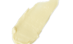 A medium elongated smear of some thick, glossy ivory hand cream, on a white background.