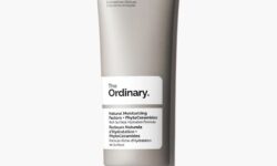 A tall flat conical matte grey plastic tube with a frosted white plastic lid that has The Ordinary Natural Moisturising Factors + Phytoceramides written in bold black writing on it, on a white background.