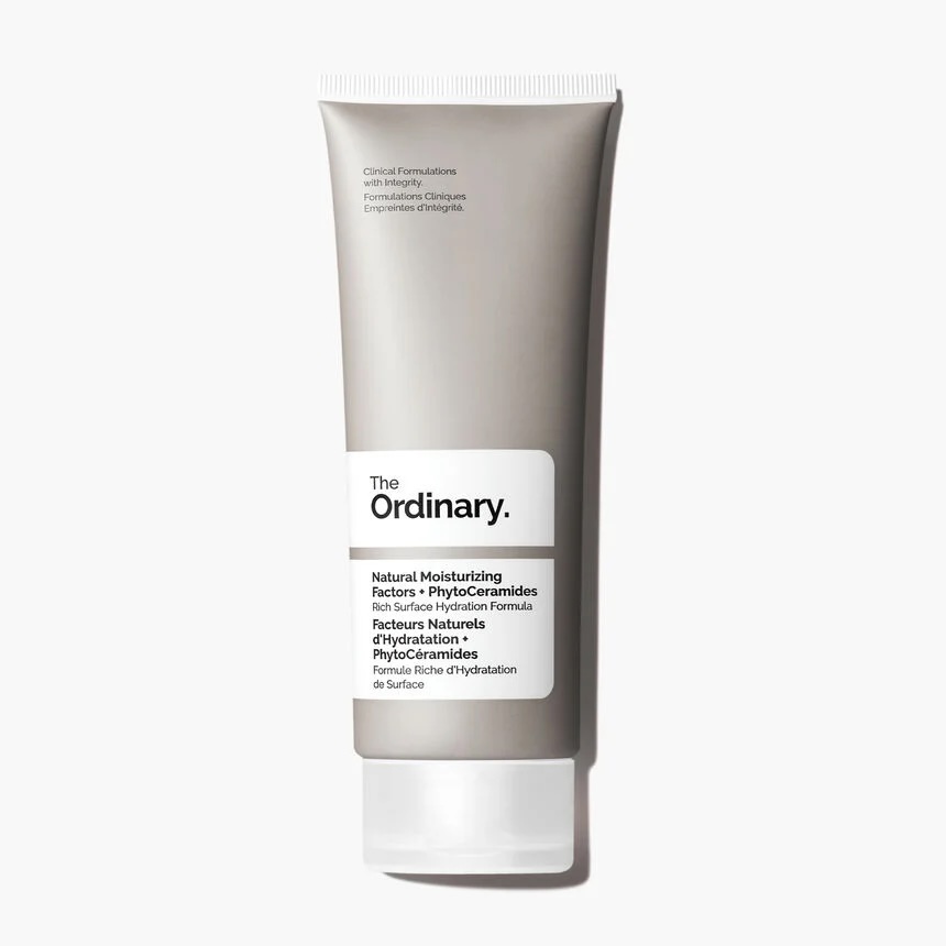 A tall flat conical matte grey plastic tube with a frosted white plastic lid that has The Ordinary Natural Moisturising Factors + Phytoceramides written in bold black writing on it, on a white background.