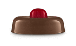 A short cylindrical glossy dark brown block of jelly face mask that has a small circular shimmering bright red piece of Jelly Face Mask sat on top of it, on a light grey background.