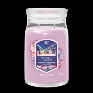 A tall cylindrical glass Jar full of some Pastel Purple Wax with a Label that has Yankee Candle written in bright white writing, Summit Stargazing written in bright white writing, and a picture of a large dark brown mountain cabin surrounded by a dark blue sky and some bright white stars on it, on a white background.
