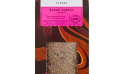 A tall rectangular black cardboard box with some bright Brown, Orange and Pink Swirls all over it and a silver label that has Tesco Finest Belgian 45% Black Forest Hot Chocolate Flakes written in bright white writing on it, and a window that you can see some of the Hot Chocolate Flakes through it, on a white background.