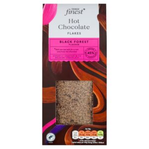 A tall rectangular black cardboard box with some bright Brown, Orange and Pink Swirls all over it and a silver label that has Tesco Finest Belgian 45% Black Forest Hot Chocolate Flakes written in bright white writing on it, and a window that you can see some of the Hot Chocolate Flakes through it, on a white background.