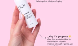 A hand holding a short cylindrical bright white plastic bottle with a bright white plastic lid that has Geek & Gorgeous 101 A-Game 5 0.05% retinal Serum written in bold black writing on it, on a bright pink background.