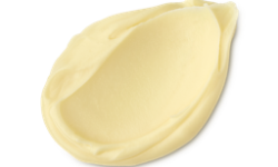 A medium circular swatch of some creamy, soft ivory white cleanser, on a white background.
