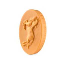 A medium creamy golden yellow oval shaped block of solid massage oil that’s covered in some bright golden yellow lustre and has a picture of a rearing horse and the words Versace Leau engraved on it, on a white background.
