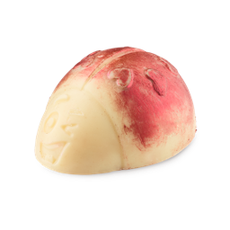 A medium creamy white Ladybird shaped block of solid Body Scrub that has some bright red heart shaped spots on it’s Wings, a large cheeky winking face engraved on it, and some bright red lustre all over it, on a white background.