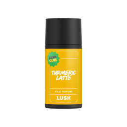 A short cylindrical black cardboard tube with a black cardboard lid and a vibrant yellow label that has Lush Turmeric Latte Solid Perfume written in bright white writing on it, on a white background.