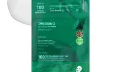 A tall rectangular medium green plastic pouch that has VT Cosmetics Pro Cica Reedel Shot 100 2 Step Hydrogel Mask written in bright white writing on it next to a circular puddle of some creamy white face mask, on a white background.