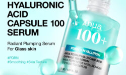 A short cylindrical clear glass bottle full of some translucent turquoise liquid with a clear rubber pipette lid and a bright silver label that has Anua PDRN Hyaluronic Acid Capsule 100 Serum written in bright white writing and a picture of a light blue stripe on it, on a gradient mint green background..