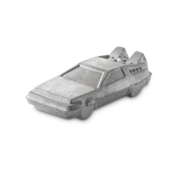 Tell Me, Doctor. Where Are We Going This Time? | Lush X Back To The Future Range A large bright silver angular DeLorean car shaped bath bomb that has some detailed windows, a tail fin, and shimmering silver lustre all over it, on a white background.