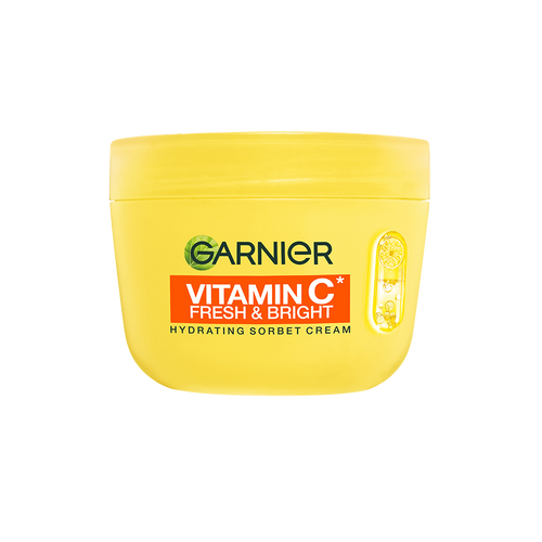 Even Your Skin Enjoys A Nice Refreshing Sorbet | Garnier Hydrating Sorbet Cream Range | Gifted A short cylindrical bright yellow plastic tub with a bright yellow plastic lid and a dark orangey red label that has Garnier written in dark green writing, Vitamin C* Fresh & Bright written in bright white writing, Hydrating Sorbet Cream written in bold black writing, and a picture of some large slices of citrus fruits on it, on a white background.