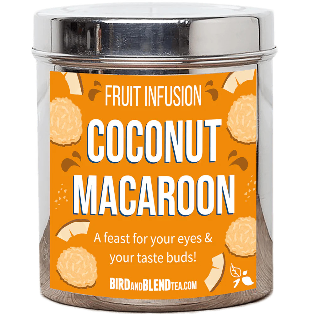 A tall cylindrical bright silver metal tin with a bright silver metal lid and a bright orange label that has Coconut Macaroon loose Leaf Tea written in bright white writing and some pictures of some golden brown coconut macaroon biscuits and some pieces of coconut on it, on a white background.