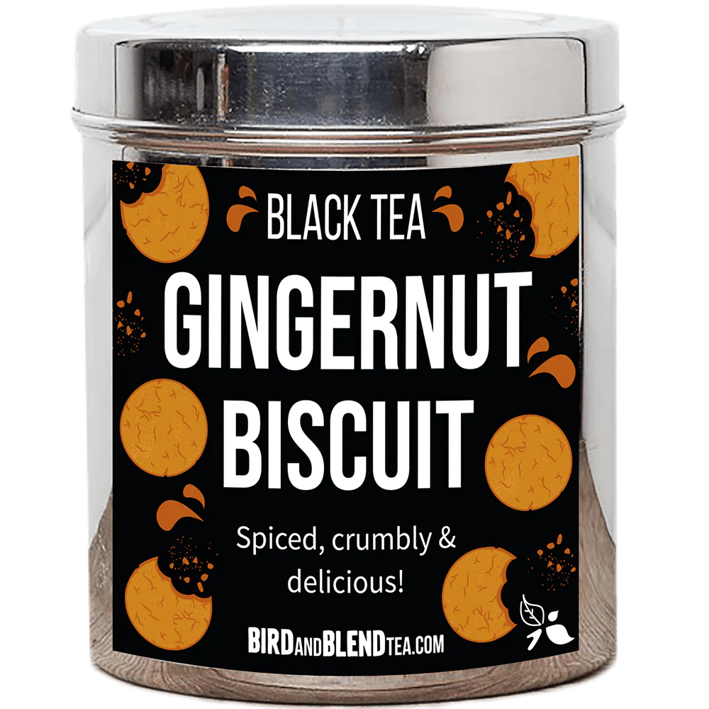 A tall cylindrical bright silver metal tin with a bright silver metal lid and a black label that has Gingernut Biscuit loose Leaf Tea written in bright white writing and some pictures of some golden brown gingernut Biscuits on it, on a white background.
