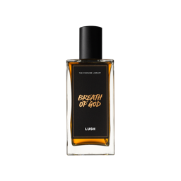 A tall rectangular clear glass bottle full of some amber coloured liquid with a metallic black lid and a black label that has Lush Perfume Library written in bright white writing and Breath Of God written in bright orange writing on it, on a white background.