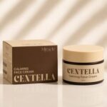 Centella Is A Miracle Worker For Dry, Red & Irritated Skin | Miracle Beauty Centella Range A short cylindrical beige glass jar with a dark tan Plastic lid, a dark brown band around it and a creamy white label that has Miracle Beauty Centella Calming Face Cream written in dark brown writing on it next to a short rectangular cardboard box that has Miracle Beauty Centella Calming Face Cream written in dark brown writing on it, on a light beige background.