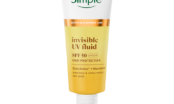 A tall tapered cylindrical bright white plastic tube with a bright white plastic lid and a label that is bright white at the top, bright orange in the middle, and bright yellow at the bottom that has Simple written in bright green writing, and Invisible UV Fluid SPF 50 written in dark brown writing on it, on a white background.
