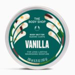 My Body Smells Anything But Basic! | The Body Shop Vanilla Range A short cylindrical Silver Metal Tin with a silver metal lid and a dark Green label that has The Body Shop Vanilla Body Butter written in bright white writing, some pictures of some small creamy white Vanilla Flowers, and some pictures of some dark Brown Vanilla Pods on it, on a white background.
