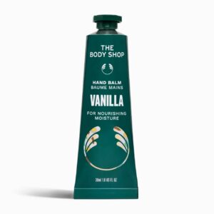 A long and thin conical metallic dark green tube with a metallic dark green lid and a dark green label that has The Body Shop Vanilla Hand Balm written in bright white writing, some pictures of some small creamy white vanilla flowers, and some pictures of some dark brown Vanilla Pods on it, on a white background.