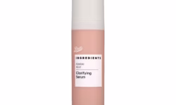 A short cylindrical Peach Pink Plastic Bottle with a matte cream Plastic Lid and a bright white label that has Boots Ingredients Clarifying Azelaic Acid Serum written in bold black writing on it, on a white background.